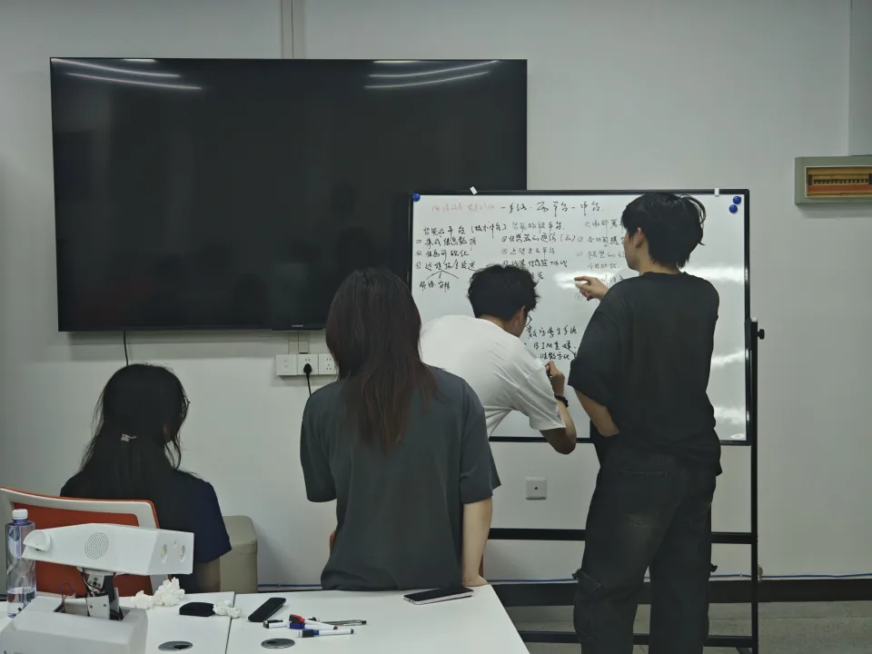 同学围绕白板讨论智慧校园的设计方案